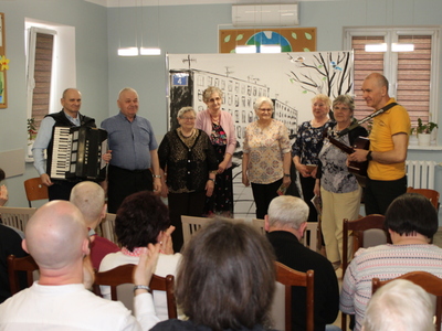 Zdjęcie przedstawia ośmioro aktorów grających w sztuce. Publiczność bije brawa.