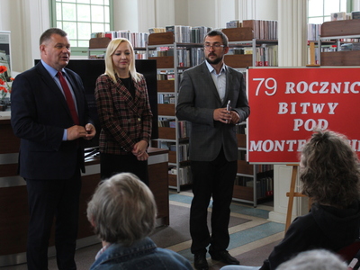 Fotografia wykonana w budynku Miejsko – Gminnej Biblioteki Publicznej w Sompolnie. Przedstawia Pana Romana Bednarka – burmistrza miasta Sompolna, panią Katarzynę Janicką – dyrektorkę biblioteki oraz pana Krzysztofa Żabierka doktora historii.