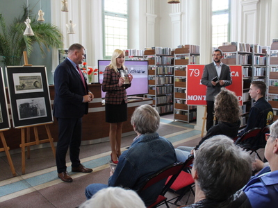 Zdjęcie przedstawia Pana Romana Bednarka – burmistrza miasta Sompolna, panią Katarzynę Janicką – dyrektorkę biblioteki oraz pana Krzysztofa Żabierka doktora historii. W tle regały z książkami oraz plakat z okazji 79 rocznicy bitwy pod Monte Cassino.