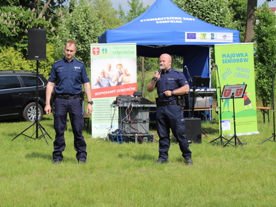 Na zdjęciu dwaj policjanci opowiadający o bezpieczeństwie seniorów.