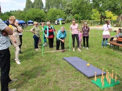 Zdjęcie przedstawia seniorów grających w kręgle.