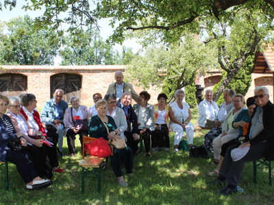 Na zdjęciu seniorzy z grupy Wiecznie Młodzi oraz z Koła Emerytów, Rencistów i Inwalidów z Sompolna. Siedzą na ławkach w parku.