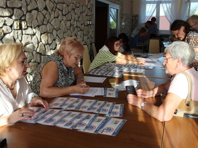 6)	Zdjęcie przedstawia pracowników MGOPS objaśniających starszej kobiecie sposób wypełnienia karty informacyjnej