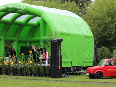 11)	Zdjęcie przedstawia występ jednego z zespołów. Po prawej stronie sceny – czerwony maluch.