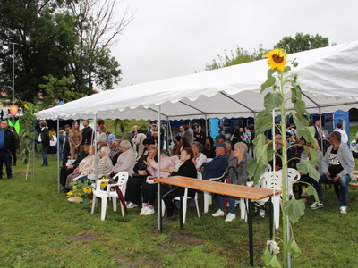 4)	Zdjęcie przedstawia uczestników imprezy siedzących pod namiotem