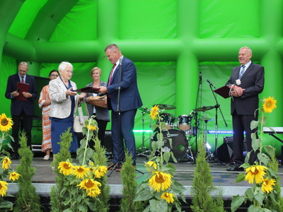 7)	Fotografia przedstawia burmistrza wręczającego Pani Genowefie Słodkiewicz tytuł zasłużony dla miasta i gminy Sompolno.