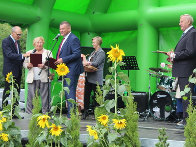 8)	Fotografia przedstawia burmistrza wręczającego Pani Grażynie Grabias - Winkler tytuł zasłużony dla miasta i gminy Sompolno.