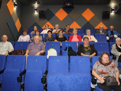 Uczestnicy Domu Dziennego Pobytu siedzący w sali kinowej.