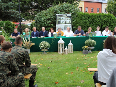 Fotografia przedstawia lektorów, a wśród nich Pana Romana Bednarka – burmistrza miasta Sompolna czytającego fragment powieści.