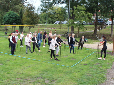 Fotografia przedstawia grupę osób ćwiczących przed rozpoczęciem marszu.