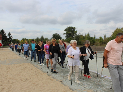 Fotografia przedstawia uczestników marszu na miejscu dawnej kolei wąskotorowej w Sompolnie.