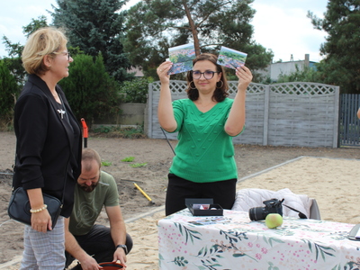 Na fotografii pracownica urzędu prezentująca widokówki z panoramą naszego miasta.