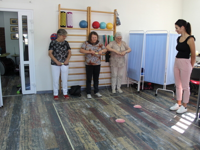 Na zdjęciu trzy seniorki podczas zabawy z nawijaniem jabłka.