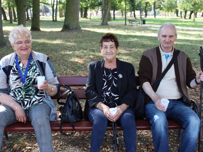 Na fotografii dwie kobiety i mężczyzna siedzący na ławce w parku we Wierzbinku.