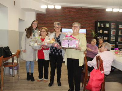 Na zdjęciu znajduje się nauczycielka przedszkola, oraz przedstawiciele Seniorów trzymający otrzymane upominki.