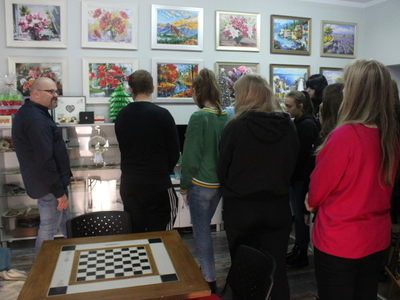 Na zdjęciu znajduje się  Dyrektora MGOPS w Sompolnie, który przedstawia młodzieży przedmioty w gablocie antykami.