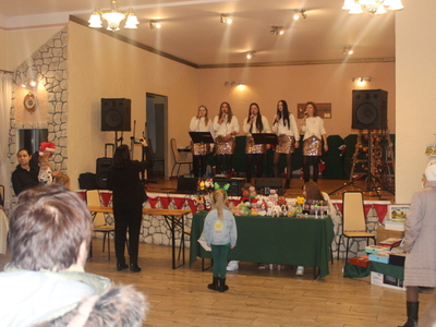 Fotografia przedstawiająca występ zespołu Effatha Chwalborzyce. Na scenie pięć kobiet w biało – złotych strojach.