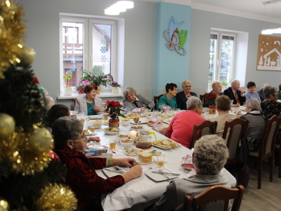 6)	Zdjęcie przedstawia seniorów siedzących przy stole wigilijnym.