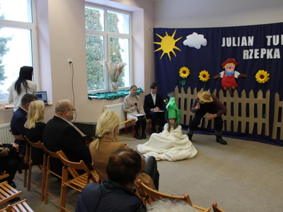 3)	Zdjęcie przedstawia młodego człowieka przebranego za ogrodnika przyglądającego się dziewczynie przebranej za rzepkę