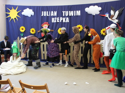 6)	Na zdjęciu młodzież przebrana za postacie z wiersza starający się wyciągnąć rzepkę.