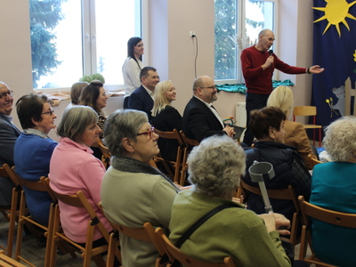 9)	Na zdjęciu mężczyzna wskazuje na młodych aktorów wychwalając ich grę.