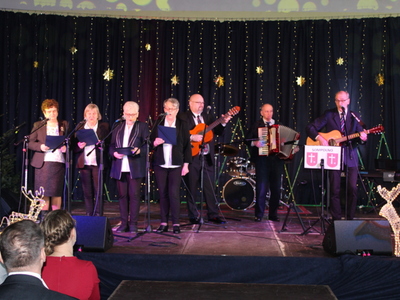 Na zdjęciu reprezentacja domu dziennego pobytu. Za nimi rozciąga się granatowa kotara ze złotymi gwiazdami.