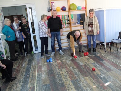 Na forografii seniorzy grający w boccie na sali rehabilitacyjnej Domu Dziennego Pobytu