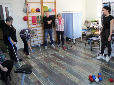 Zdjęcie wykonane na sali rehabilitacyjnej w Domu Dziennego Pobytu gdzie seniorzy rozgrywają runde boccie