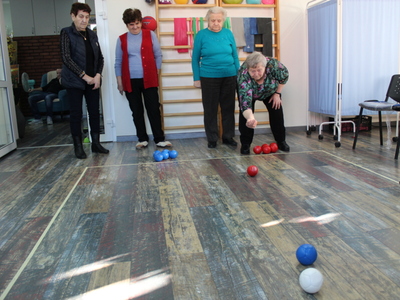 Zdjęcie przedstawia Panią wykonującą rzut kulą do boccie