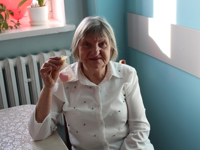 4.	Zdjęcie przedstawia Seniorkę, która prezentuje w ręce otrzymany upominek