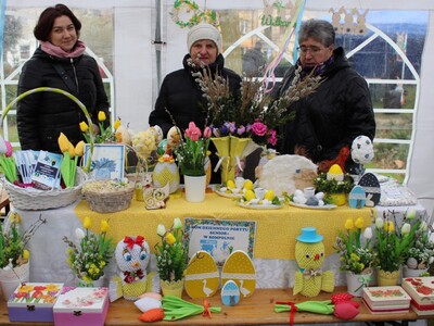 Zdjęcie przedstawia stoisko Domu Dziennego Pobytu  prezentowane przez dwie Seniorki z DDP oraz pracownicę ośrodka.