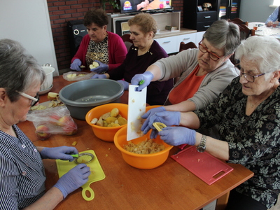 1)	Zdjęcie przedstawia seniorki krojące warzywa na sałatkę jarzynową.