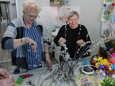 3)	Na fotografii dwie starsze panie układające bukiet z palm wierzbowych.