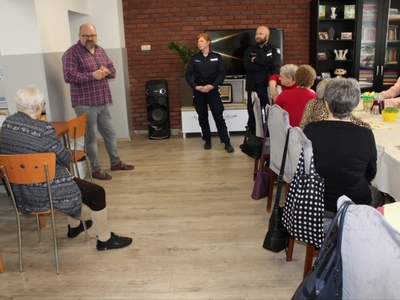 3)	Na zdjęciu widzimy grupę Seniorów z Domu Dziennego Pobytu, Dyrektora MGOPS w Sompolnie oraz policjantów przemawiających na sali Głównej do zgromadzonych.