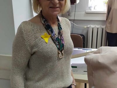 8)	Na fotografii pracownica mgops z przypiętym żonkilem.