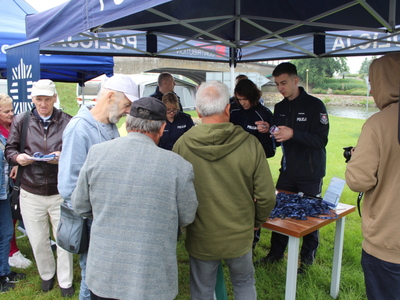 4.	Na zdjęciu widać grupę seniorów przy stoisku Komendy Powiatowej Policji w Poznaniu