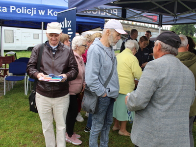 5.	Fotografia przedstawia seniorów podchodzących do stoiska Komendy Powiatowej Policji w Poznaniu