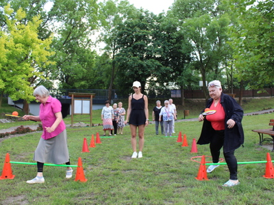3. Zdjęcie wykonane w parku,  przedstawia pokonywany przez seniorów tor przeszkód .