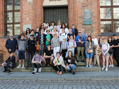 1)	Zdjęcie grupowe przedstawiające wszystkich uczestników wycieczki do Torunia. Wykonane na schodach Domu Mikołaja Kopernika.