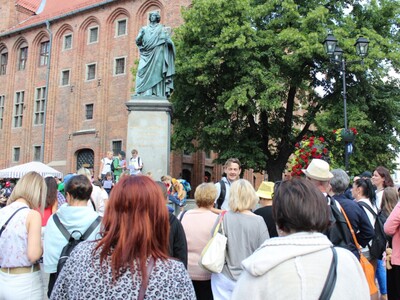 4)	Fotografia przedstawia zwiedzających przy pomniku Mikołaja Kopernika.