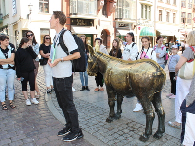 5)	Na zdjęciu zwiedzający przy Pomniku Osiołka.