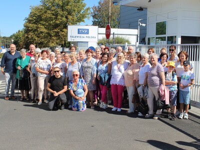 1)	Zdjęcie grupowe wykonane przed siedzibą telewizji polskiej w Warszawie. Przedstawia grupę seniorów z  Sompolna i okolic wraz z opiekunami.