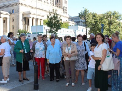5)	Na fotografii grupa seniorów wraz z opiekunami przy Pałacu Kultury.