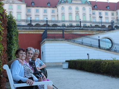 6)	Na zdjęciu seniorki siedzące na ławce. W tle zamek.