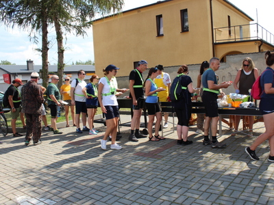 4)	Na fotografii uczestnicy rajdu rowerowego częstowani posiłkami z grilla.
