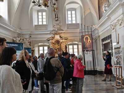 2)	Na fotografii wnętrze sali rycerskiej i uczestnicy wycieczki