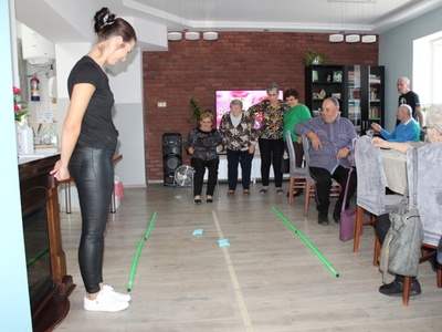 5)	Na zdjęciu seniorzy w trakcie zabawy z woreczkami.