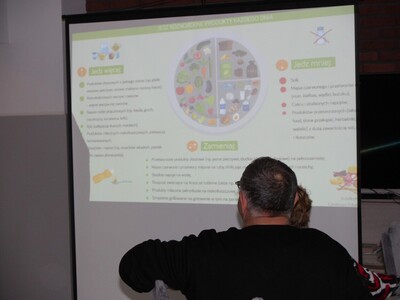 1 Zdjęcie wykonane na Sali głównej DDP. Przedstawia slajd z prezentacji multimedialnej w tematyce dietetyki.