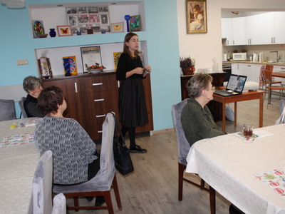 2. Zdjęcie przedstawia Panią dietetyk omawiającą zagadnienia z dietetyki  podczas spotkania z seniorami z DDP