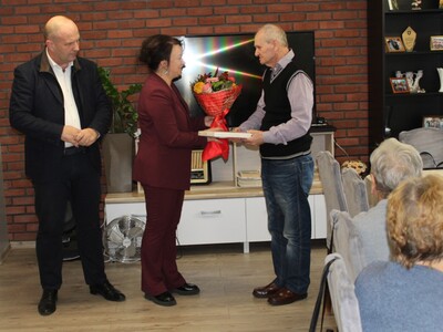 3)	Fotografia przedstawia kierownik administracyjną urzędu wręczającą uczestnikowi bukiet kwiatów